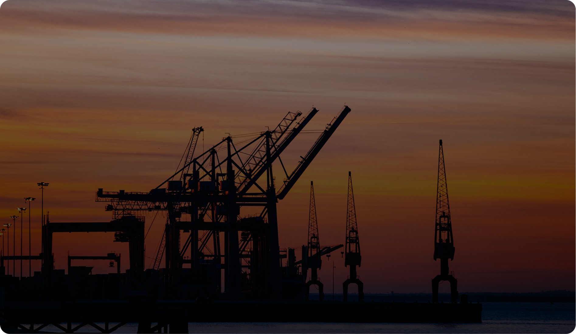 Industrial port cranes at sunset